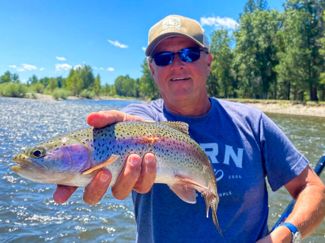 Steve with a bright rainbow out of a brush pile - Full Moon Fishing in Montana 