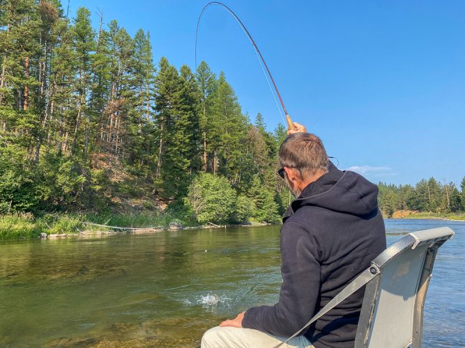 Charlie fighting a decent cutthroat in the canyon - August Fishing