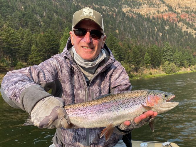 Jim with a thick rainbow in fast water - August Fishing